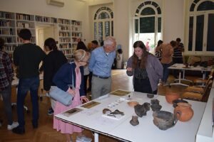 Student Renée de Vries explains “her” tomb assemblage consisting of pottery and metal ornaments to visitors.